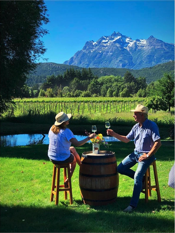 Casa Yagüe vineyard owners toasting in front of mountains